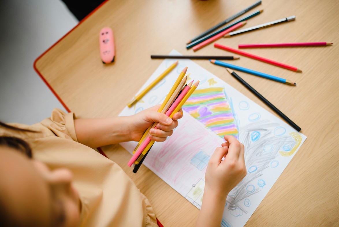 Using coloured pencils to draw a house.