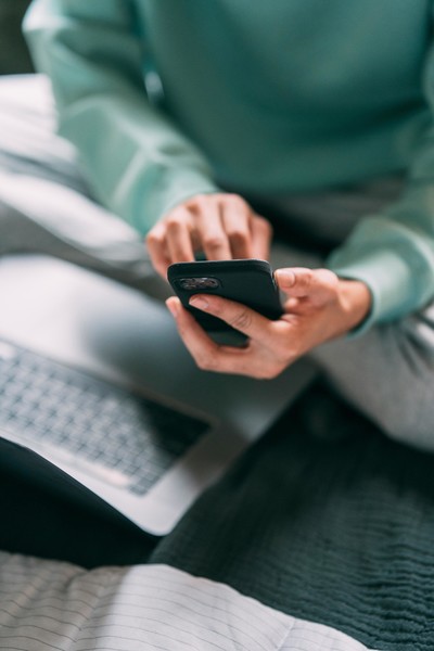 Making a phone call while sitting by laptop