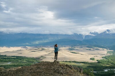 Woman looking out toward a mountain landscape, symbolizing inner strength, personal growth, and resilience in strength-based therapy.