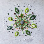 Nature mandala made from leaves, flower petals, and pebbles—part of a simple summer art activity to support stress relief and mindfulness.