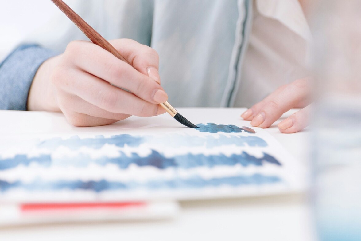 Person painting lines on paper during a virtual art therapy session, representing accessible, pay-what-you-can art therapy for adults in Ontario.