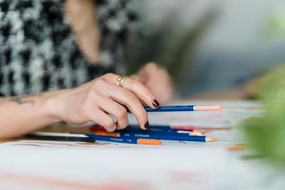 Close up of a hand grabbing a pencil, representing art therapy with an art therapy student